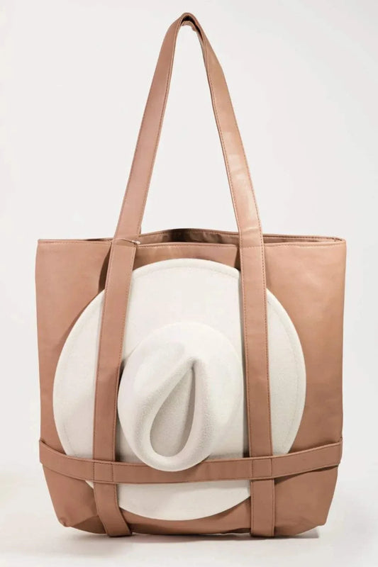 Beige hat storage bag carrying a white wide-brim hat, designed for travel and protection against bending or crushing.