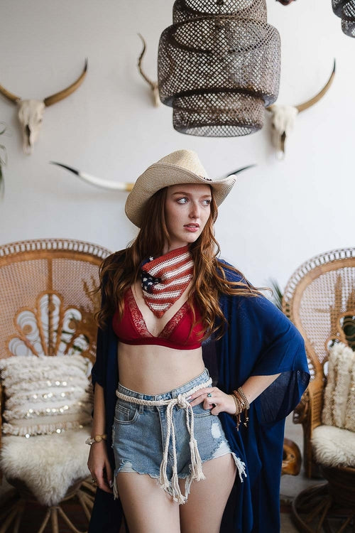 Stylish boho outback hat worn with a red bikini top and denim shorts in a chic setting