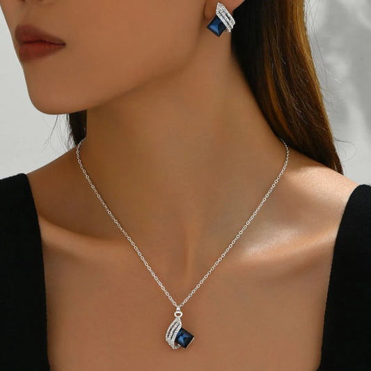 Elegant stainless steel crystal jewelry set featuring a necklace and earrings with dark blue crystals