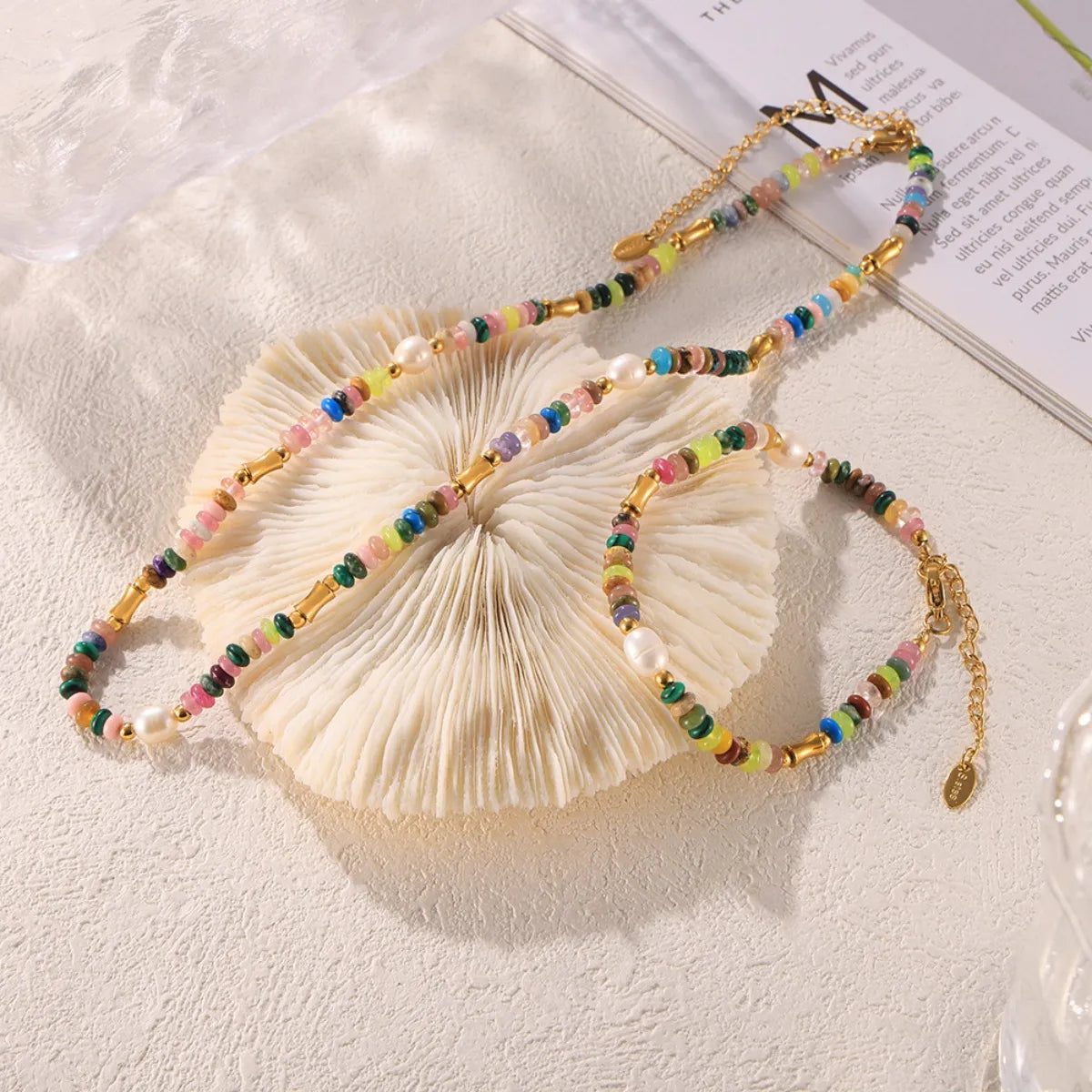 Bohemian natural stone jewelry set featuring colorful beads and gold accents on a textured surface